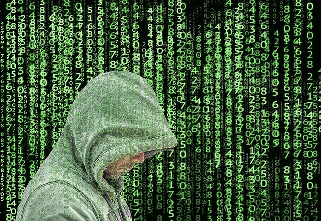 Image of computer hacker against a background of computer code, emphasizing the increasing need for protection against cyber security threats to SMBs.