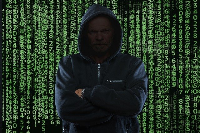 Image of computer data and a hooded computer hacker, representing the need for a small business disaster recovery plan.